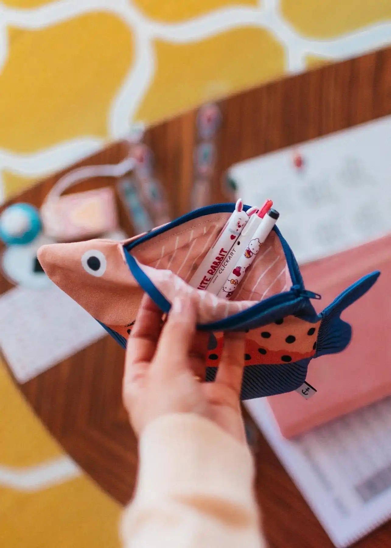 Fish-shaped pencil case with pens.